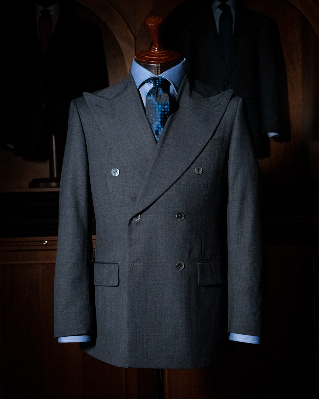 Abito Grinta Doppiopetto Grigio Scuro Quadri Blu - Elegante e distintivo, perfetto per il business con rever ampio e dettagli sartoriali impeccabili.